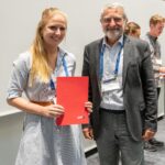 Ceremonia de entrega de premios EMS2022: Amandine Kaiser, ganadora del premio Young Scientist Conference Award, con el vicepresidente Dominique Marbouty (derecha)